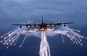 Avion des opérations spéciales MC-130 Combat Talon, ici entouré de flares, capable de larguer des tracts à haute comme à basse altitude