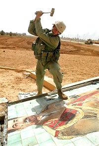 Soldat US sur un portrait de Saddam Hussein